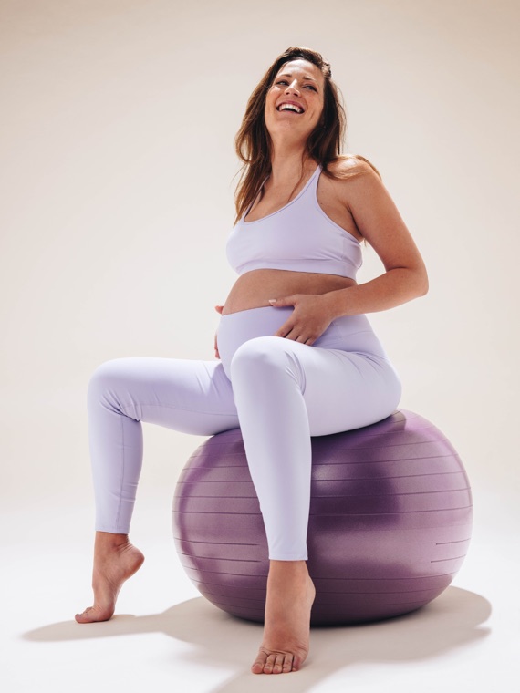 Pregnant woman smiling on an exercise ball